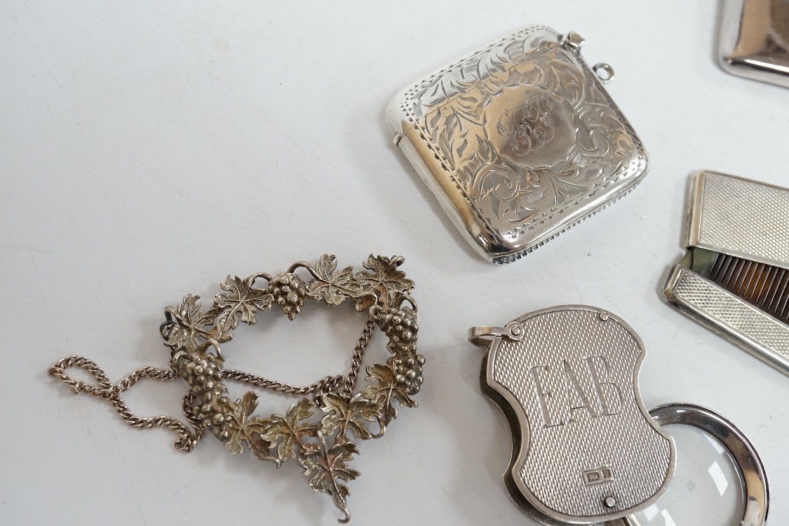 A small group of collectable silver including an Edwardian card case, a set of three modern silver wine labels with applied fruiting vine border, one a.f. London, 1975, a vesta case, travelling comb and folding eye glass